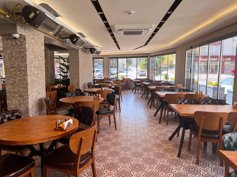 Gönül Sofrası yemek salonu, ahşap masalar ve geniş camlar
